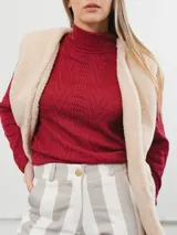 Chaleco color crema con textura de piel sintética, sin mangas y con forro interno.