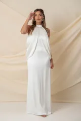 Vestido largo de novia en crepe satén de seda natural, con cuello halter y diseño drapeado que cae desde el cuello hacia la espalda.
