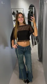 Top tipo capa de tul negro con transparencias, corte cropped y mangas amplias tipo murciélago.