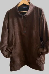 Buzo de pana color marrón con cuello alto y cierre frontal parcial. Presenta bolsillos laterales y un parche con logo en el pecho.