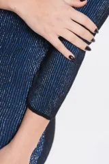 Vestido corto de tejido con brillo, color azul y negro, de manga larga y diseño ajustado.