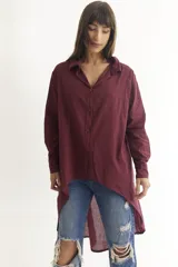 Camisa color beige de manga larga con cuello clásico, cierre frontal con botones y bajo irregular.