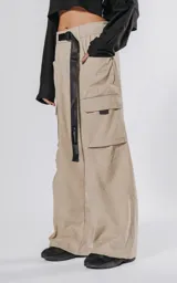 Pantalon cargo color vison de silueta oversize y pierna recta ancha. Cuenta con cintura elastizada, cinturón integrado con hebilla de seguridad, múltiples bolsillos laterales con solapa y detalles reflectivos.