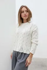 Sweater color crema tejido con diseño de trenzas y calados en el ruedo.