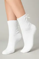 Medias blancas de algodón, caña media, con diseño de punto trenzado y lazo decorativo en la parte superior del borde.
