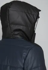 Campera puffer verde militar con capucha negra de cuero sintético, cierre frontal con cremallera y bolsillos laterales con cierre.