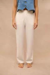 Pantalón de vestir color crudo, de corte recto y tiro alto, con detalles de trabillas y hebillas ajustables en la cintura.
