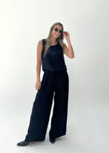 Conjunto de musculosa y pantalón palazzo color dorado brillante. La musculosa es sin mangas y el pantalón es de corte ancho con cintura alta.