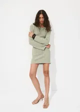 Vestido corto de punto color verde, de manga larga, cuello redondo y silueta evasé, con diseño texturizado.