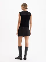 Minifalda negra con bordado frontal de lentejuelas en forma de cerezas, detalle de cinto tejido en lana y volado de organza plisada en el ruedo.