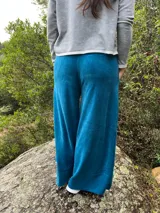 Pantalón palazzo de tiro alto, color azul, confeccionado en plush de algodón con faja ancha en la cintura y bolsillos laterales amplios.