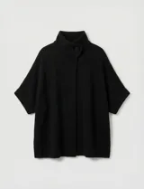 Capa tejida color fucsia, con cuello alto abotonado y mangas cortas estilo japonesa. Tejido de punto grueso.