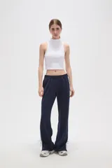 Pantalon deportivo de corte recto y tiro medio, color tostado, con cintura elástica y franjas laterales en tono más claro. Presenta aberturas en los tobillos con cordones ajustables.