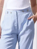 Pantalón de lino estampado a rayas verticales celestes y blancas, marca Zac & Rachel. Tiene pretina con botones, cierre y broche metálico, bolsillos delanteros y bolsillos traseros simulados.