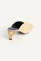 Zapato de tacón destalonado estilo mule, totalmente revestido de abalorios y lentejuelas en tonos claros, con escote en pico, punta cuadrada y tacón medio metalizado.