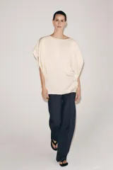 Top fluido de manga corta de Zara Woman Collection, confeccionado en hilatura de viscosa de color crudo. Cuenta con cuello barco, bajo recto y cierre en la espalda con pequeña abertura y botón.