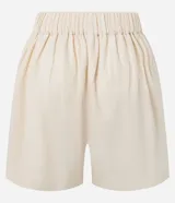 Short de cintura alta color crema, con bolsillos laterales y bordados abstractos en los costados.