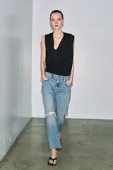 Jeans de tiro medio con corte recto y largo al tobillo. Presentan diseño de cinco bolsillos, cierre frontal con cremallera y botón, y ruedo deshilachado.