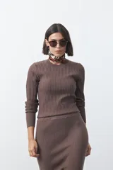 Sweater de tejido tipo rib, color negro, con cuello redondo y mangas largas. Presenta una textura acanalada y un ajuste al cuerpo.