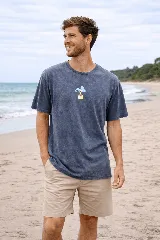 Remera de algodón premium con efecto lavado, color azul, de manga corta y cuello redondo. Presenta un pequeño estampado central con un diseño de hongo antropomórfico.