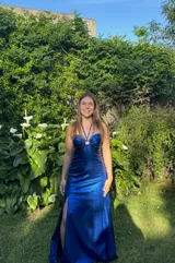 Vestido largo de fiesta color celeste, con top de lentejuelas doradas, argolla en el busto, breteles finos y espalda descubierta.