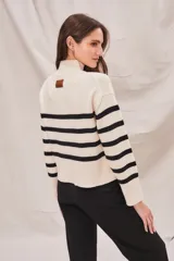 Polera de cuello alto, color blanco con rayas horizontales marrones. De calce ajustado y manga larga con puños acampanados.