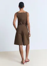 Short marrón de corte recto y largo bermuda, con diseño de pinzas en la parte delantera, bolsillos laterales y cierre frontal oculto.
