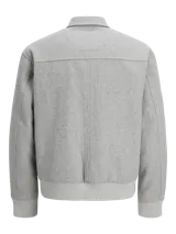 Campera bomber corta de paño gris claro, con cuello camisero, cierre frontal metálico completo y bolsillos laterales ribeteados. Presenta puños y cintura elasticados en rib acanalado.