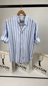 Camisa de algodón a rayas celestes y blancas, con cuello mao y mangas largas.