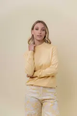 Buzo de tejido fino color amarillo claro, con cuello semi alto, manga larga y calce regular.