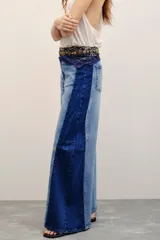 Jean de corte wide leg con diseño bicolor que combina tonos de denim azul claro al frente y azul oscuro en los laterales.