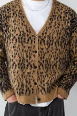 Cardigan de punto con estampado animal print, cuello en V y cierre frontal de botones. Presenta un diseño de textura suave y corte holgado.