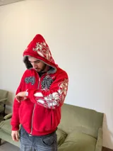Campera reversible con cierre frontal, confeccionada en algodón de alto gramaje con estampa plastisol y bordado con aplique en un lado, y tela polar de pelo largo en el reverso. Presenta diseño oversize, capucha integrada y puños acanalados.