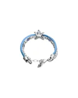 Pulsera de diseño náutico con hilo de seda azul y cuentas metálicas plateadas. Presenta un dije central en forma de estrella de mar y pequeños cristales facetados en tono azul.