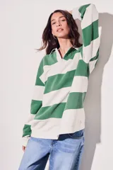 Sweater estilo polo de corte oversize, con diseño de rayas horizontales anchas en tonos camel y bordó. Presenta cuello camisero con cierre frontal parcial y mangas largas con puños ajustados.