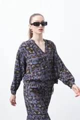 Blusa de manga larga con cuello en V y estampado abstracto en tonos azul y marrón oscuro.