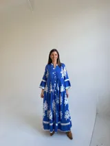 Vestido largo color azul con estampado ornamental en color blanco, escote en V con botones frontales y mangas tres cuartos con volados.