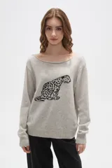 Sweater de tejido de punto color beige con estampado jacquard de leopardo en color negro. Presenta cuello redondo amplio y puños y ruedo acanalados.