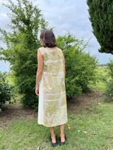 Vestido midi de corte evasé con estampado de hojas en tonos verdes y beige.