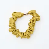 Set de cuatro gomas para el pelo tipo scrunchie, dos en color verde oliva liso y dos con estampado animal print, todas con detalle metálico central.