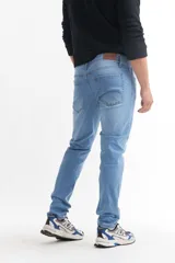 Pantalón de jean azul de corte slim, tiro alto y largo hasta el tobillo.