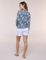 Campera liviana blanca de silueta entallada con protección solar UPF 50, cuello alto y cierre frontal completo. Cuenta con mangas largas y bolsillos laterales.