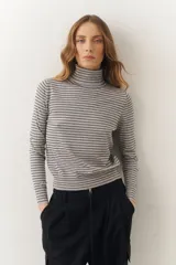 Polera de tejido de punto fino con diseño de rayas horizontales, cuello alto y manga larga.