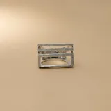 Anillo de plata 925 con acabado satinado, diseño geométrico de líneas horizontales paralelas y estructura rectangular abierta.