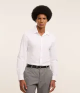 Camisa de hombre, corte slim, color blanco, confeccionada en algodón y poliéster con tecnología Easy Care que ofrece elasticidad y secado rápido. Presenta cuello inglés y manga larga con puño abotonado.