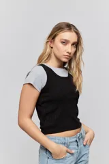 Musculosa de calce ajustado confeccionada en tejido acanalado, con escote redondo y detalle de puntilla en el escote y las sisas.