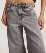 Pantalón skater de jean color gris con lavado dirty, tiro bajo, trabillas anchas en la cintura y bolsillos diferenciados.