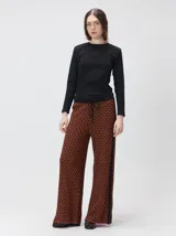 Pantalón de tejido jacquard con textura geométrica en tonos tostado y beige, de tiro medio, cintura elástica con cordón de ajuste y pierna ancha.