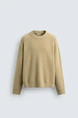 Jersey de punto con textura efecto pelo, corte relajado, cuello redondo y manga larga con acabados en rib.