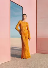 Vestido largo de punto calado color naranja, con cuello redondo y mangas largas acampanadas. Diseño de tejido abierto con textura geométrica.